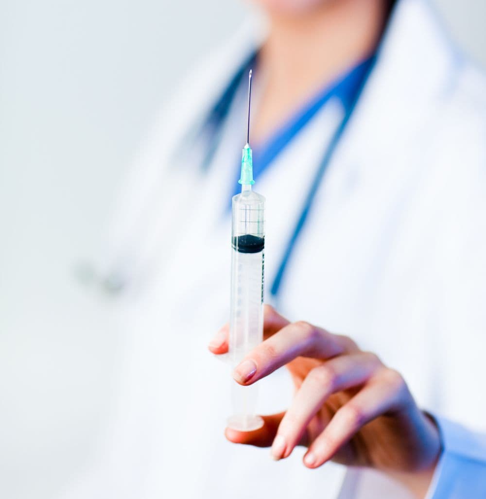 Pharmacist holding a vaccine syringe